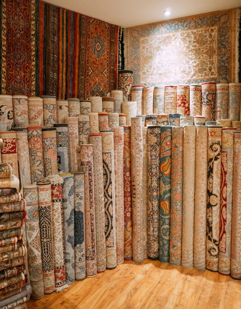 A vibrant collection of Turkish rugs displayed in an Istanbul store, showcasing intricate patterns and rich textiles.