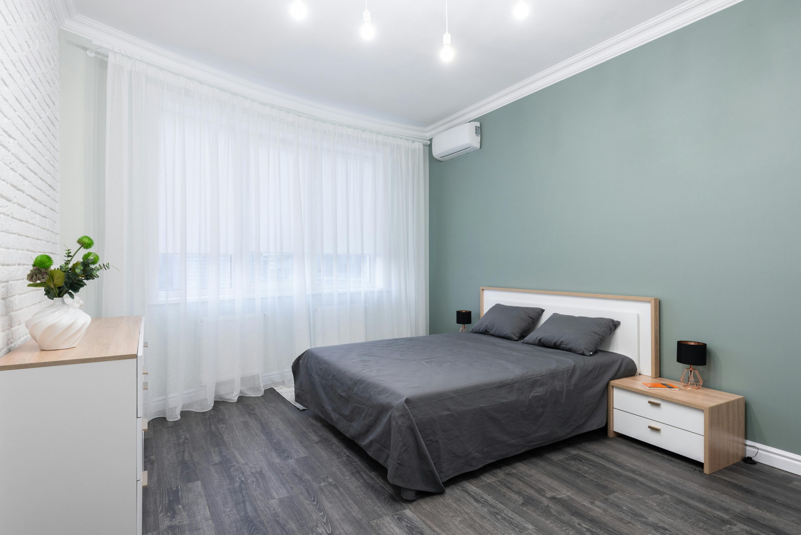 A serene modern bedroom with gray accents, soft lighting, and minimalist design.