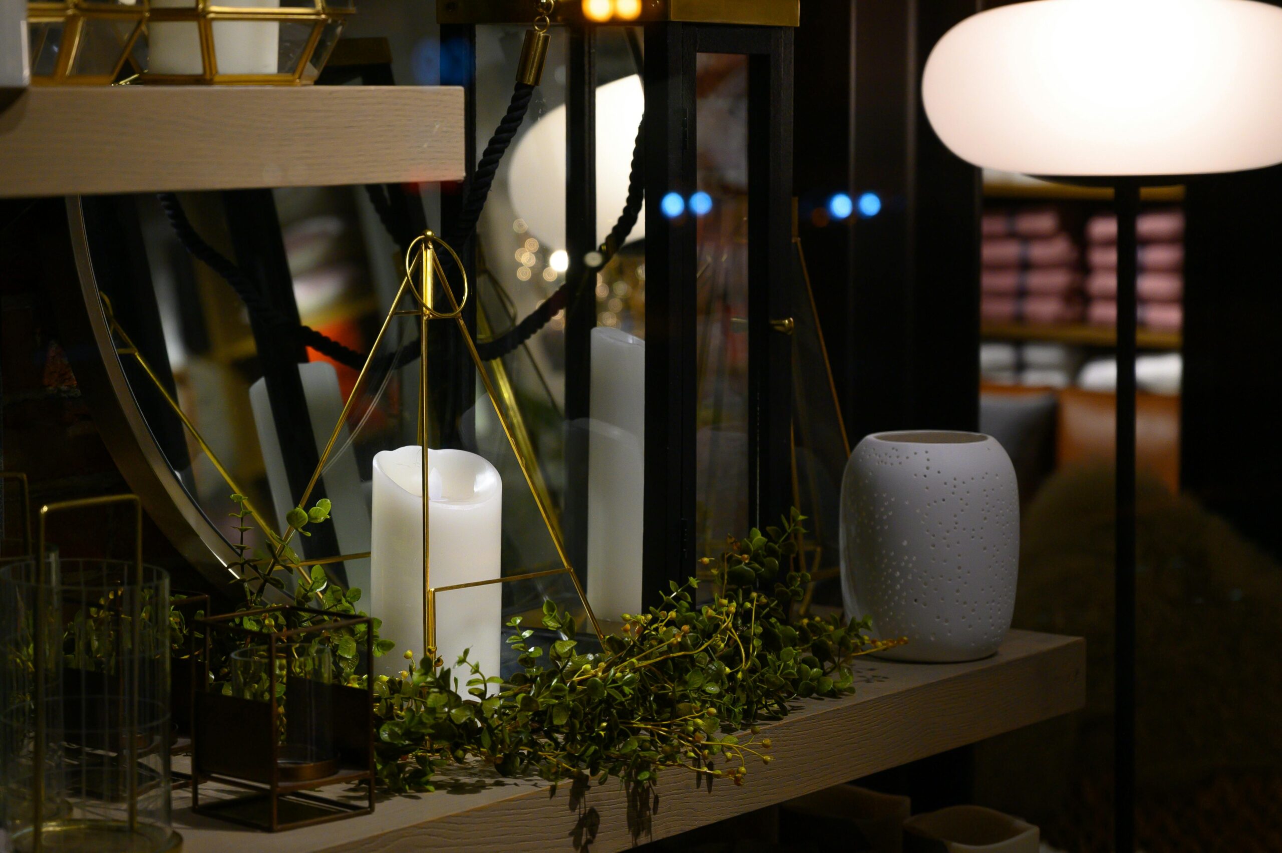 A cozy indoor setup featuring a decorative candle and various elegant items on a wooden shelf.
