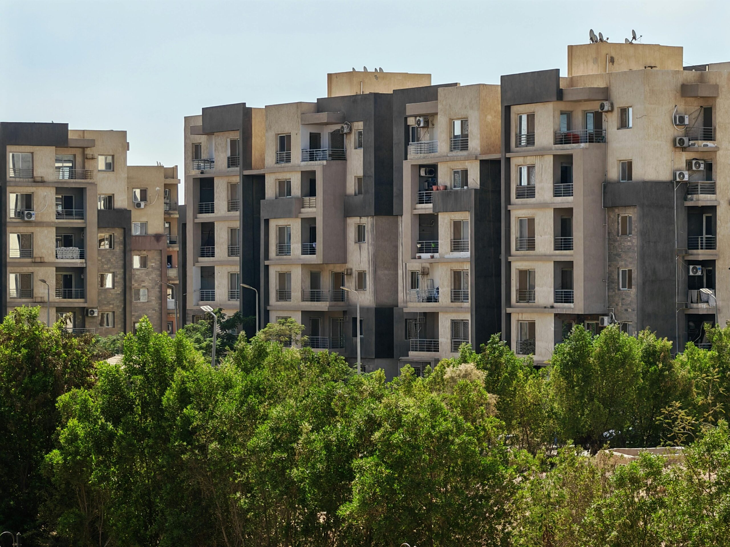 Contemporary apartment buildings surrounded by lush greenery.